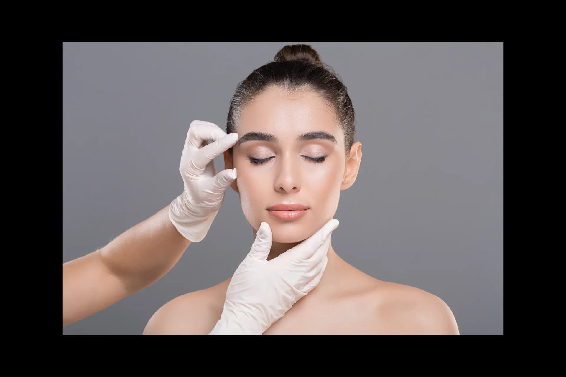 Woman with radiant skin receiving an aesthetic facial assessment from a gloved provider at MC Aesthetics in McMinnville, Oregon